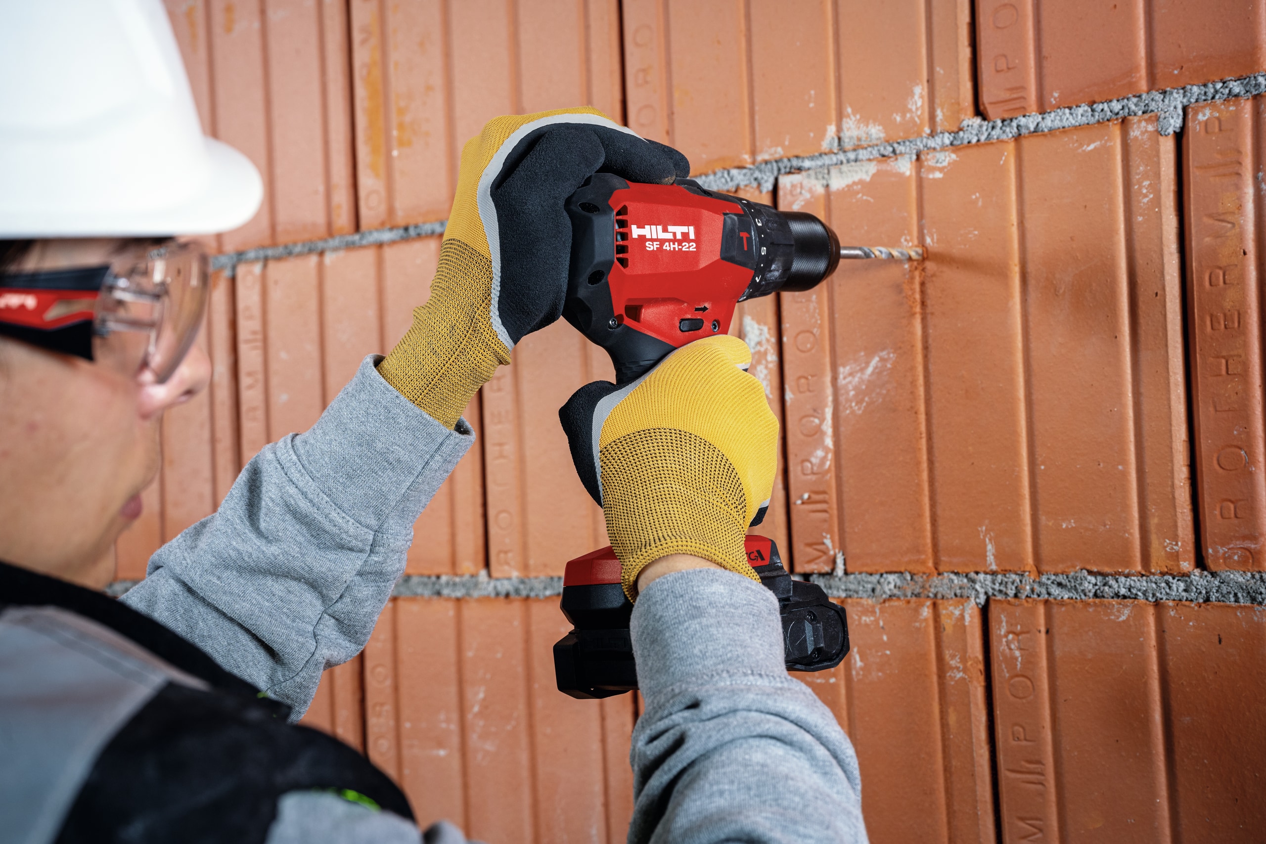 Worker drilling brick wall with SF 4H-22