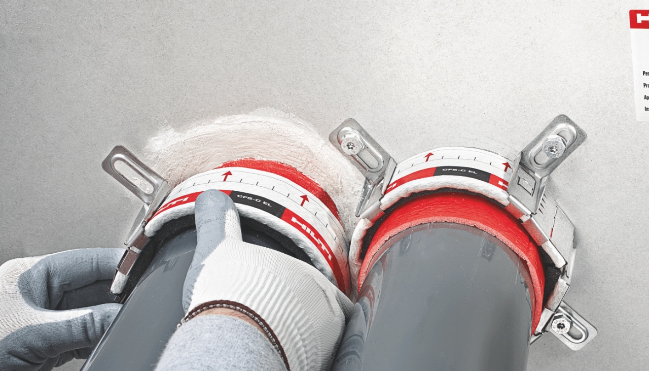 Hilti firestop sealing is being installed around large pipes going through wall. 