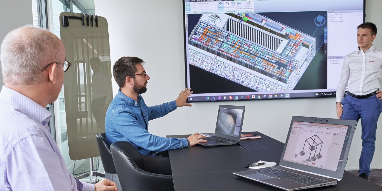 Hilti engineers discussing a MEP project on multifunction screen.