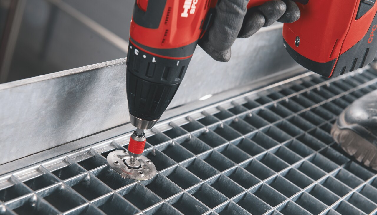 Worker applying Hilti direct fastening solution into a metal floor construction. 