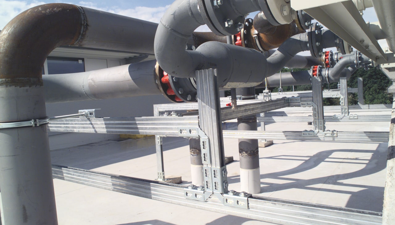 Metal construction support system holding large pipes.