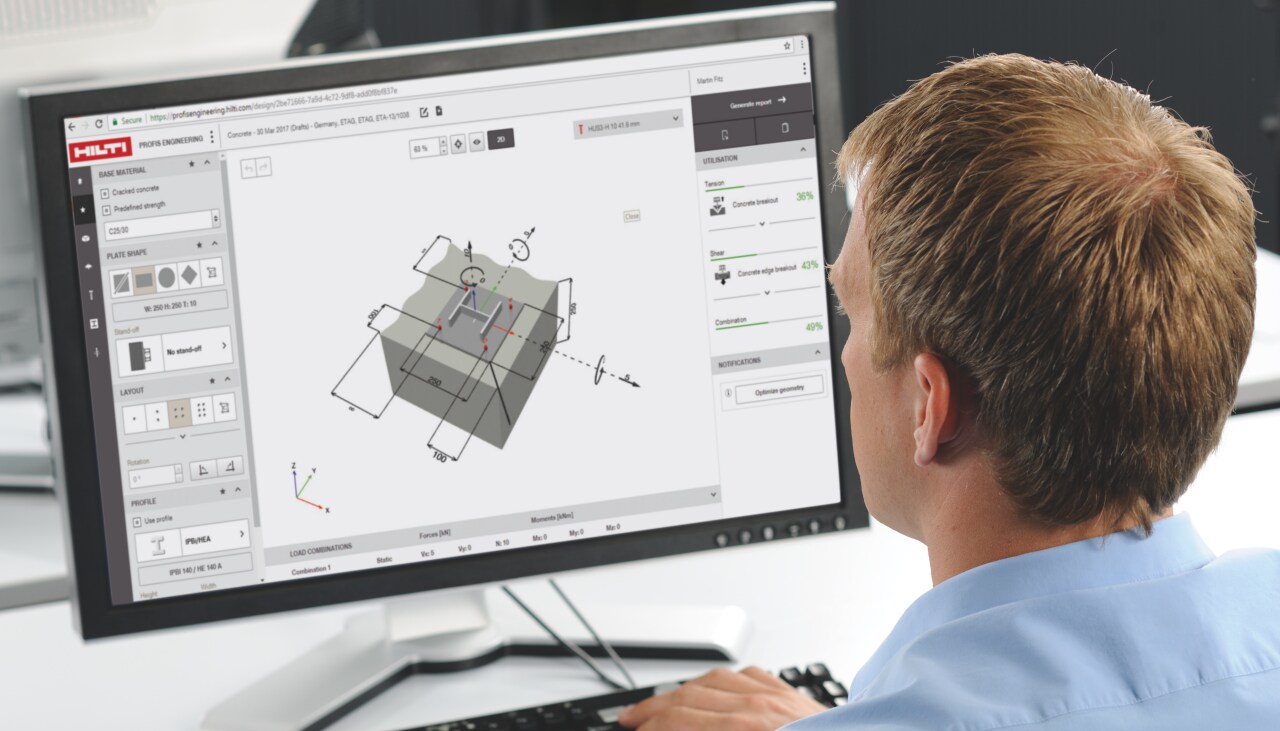 Man in the office using computer, on the screen is PROFIS engineering software.