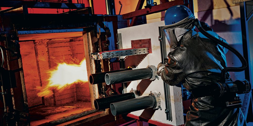 Fire brigade worker is testing Hilti firestop solution in a construction hall.