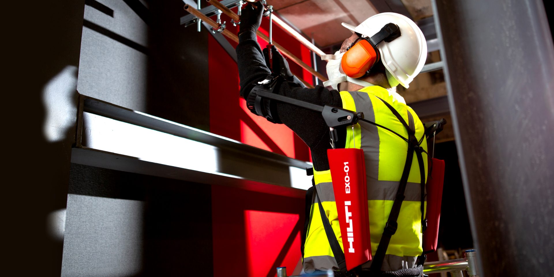 Worker wears EXO-01 exoskeleton while working overhead 