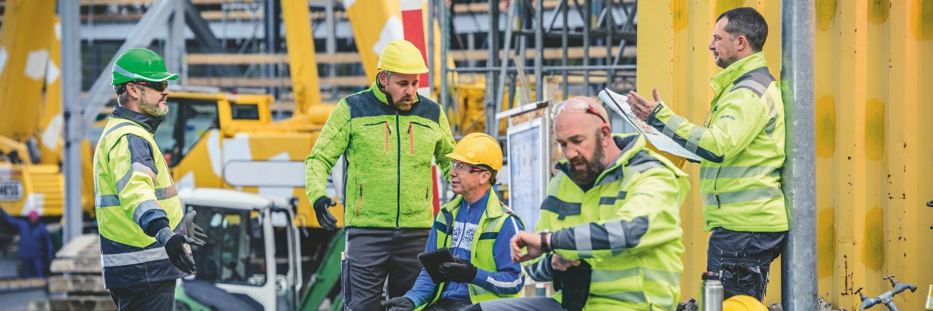 Group of construction workers talking on a construction site.