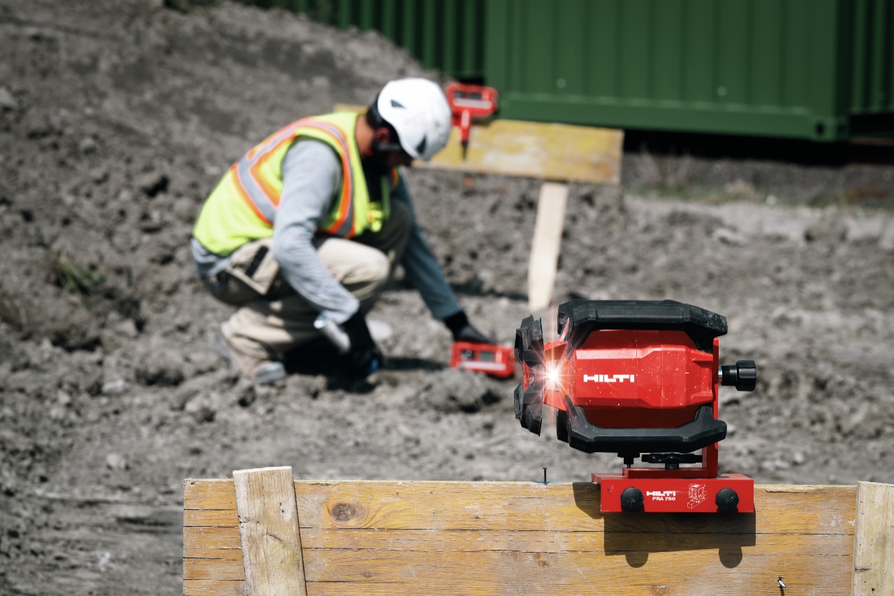 Construction worker measuring with Hilti laser. 