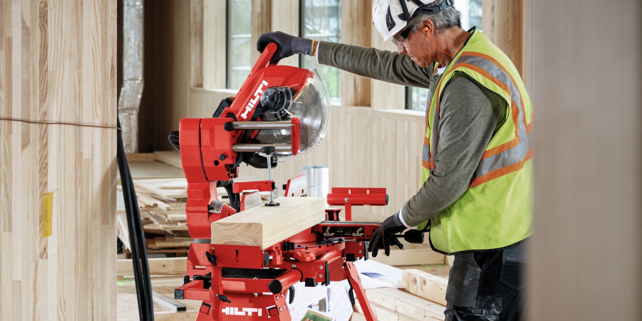 Man using red Hilti mitre saw.