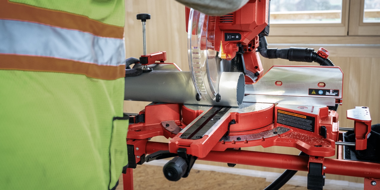 Man using red Hilti mitre saw.
