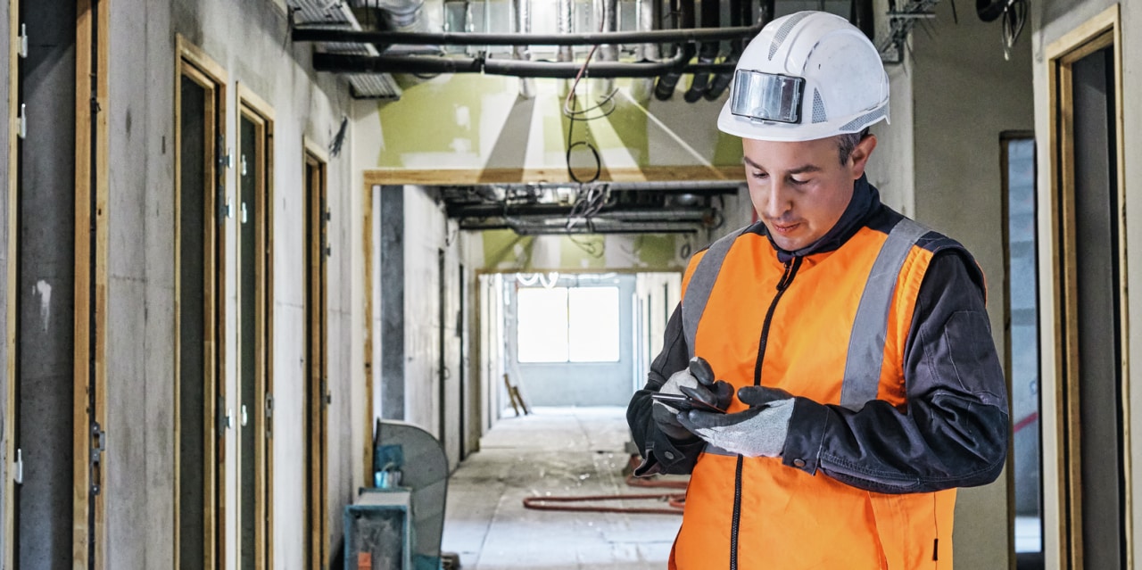 Construction worker using phone on site.