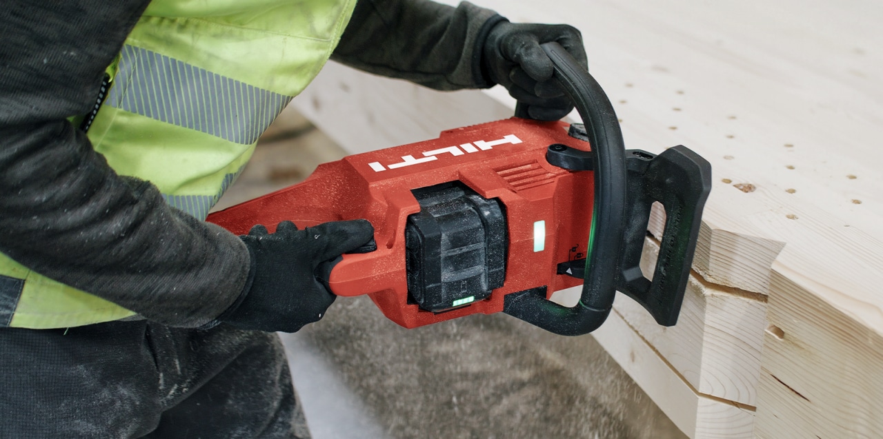 man using cordless chainsaw