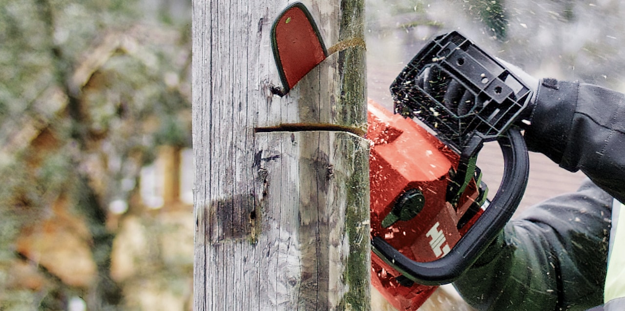 man using cordless chainsaw