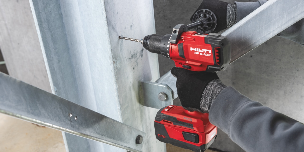 Man drilling hole to steel construction with Hilti red drill. 