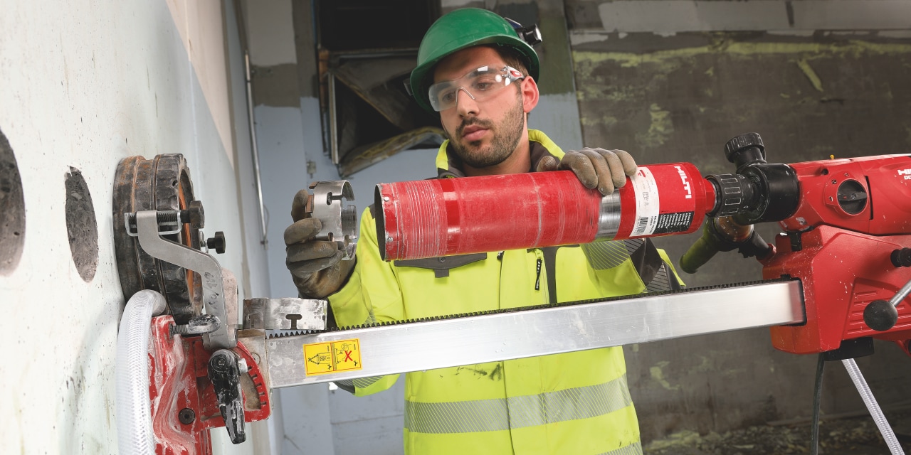 Construction worker is changing diamond blade on Hilti core drill. 